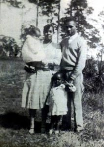 Dec. 25, 1951: Bombing of the Moore Family Home (This Day in History) - The Moore family: Harriette holds daughter Evangeline, Harry, and Annie Rosalea (standing) | Zinn Education Project: Teaching People's History