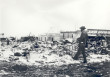 Tulsa Race Riot ruins, an African American man with a camera suveying the rubble.