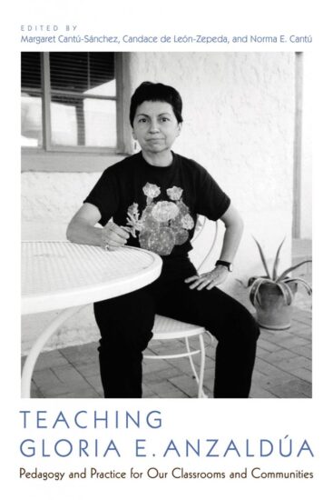 Gloria Anzaldua sitting at a table