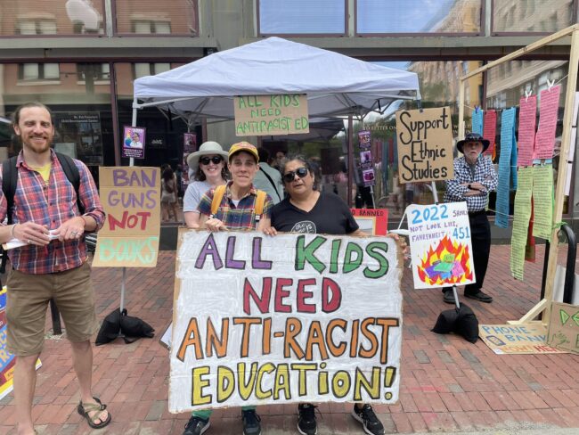 People holding sign at Teach Truth Day of Action