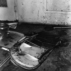 Raiford prison uprising aftermath, showing overturned chairs and blood on the wall.
