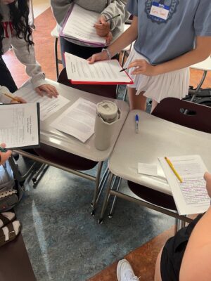 documents in students hands working in classroom