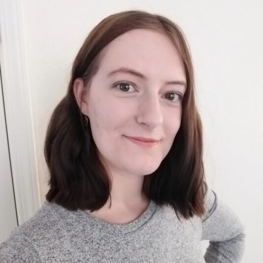headshot of woman in gray shirt smiling